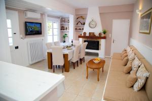 a living room with a couch and a table with chairs at Aroura Homes Spetses 3BR 2BA in Spetses
