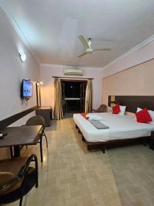 a bedroom with a bed and a table and a tv at The Pentacon A Resort in Canacona