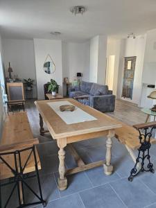 a living room with a wooden table and a couch at Le Rustique Lourdes Cœur de vIlle in Lourdes
