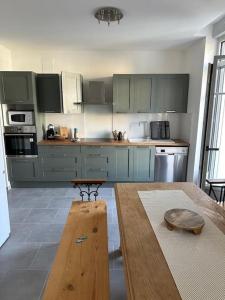 a kitchen with blue cabinets and a wooden table at Le Rustique Lourdes Cœur de vIlle in Lourdes +10 photos