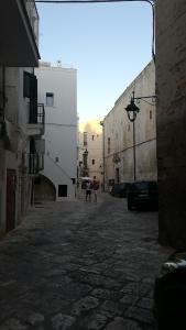 an alley with two people walking down a street at NM charming suite in Monopoli