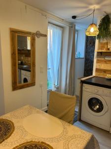 a kitchen with a table and a washing machine at La Balade in Saint-Aubin