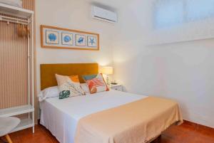 a bedroom with a white bed with pillows on it at La Tartana Hotel Boutique in La Herradura