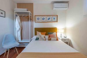 a bedroom with a white bed and a blue chair at La Tartana Hotel Boutique in La Herradura