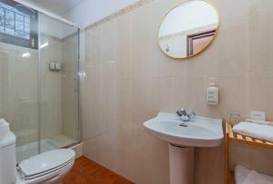 a bathroom with a sink and a toilet and a mirror at La Tartana Hotel Boutique in La Herradura