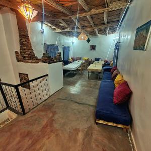 a living room with a long blue couch in a room at Riad Taourirte in Tinerhir