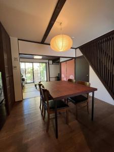 Un comedor con mesa y sillas de madera. en Sennichi House, en Kanazawa