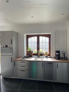 a kitchen with white cabinets and a sink at Bien-Être au B in Sart-lez-Spa