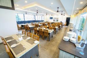 a restaurant with tables and chairs in a room at Goodland Elegance in Trivandrum