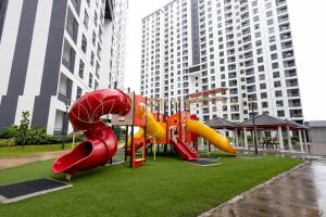 a playground with a slide in a park with tall buildings at KSL Residences 2 Premier Suites Johor Bahru in Johor Bahru