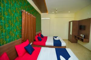 a bedroom with two beds and a couch at My Rooms Channapatna in Channapatna