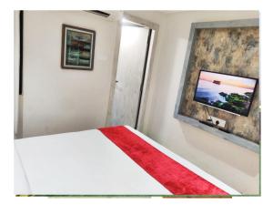 a bedroom with a white bed with a red blanket at Hotel Grand Girdhar in Indore