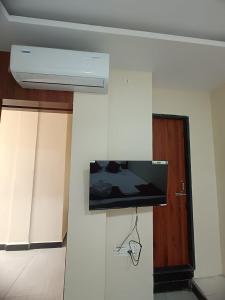 Un televisor de pantalla plana en la pared de una habitación. en Vakratunda Home Stay, en Ujjain 3 fotos más