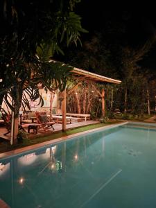 a swimming pool with a pergola and a picnic table at Haradali's Home in Arusha