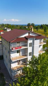 an apartment building with a red hotel sign on it at Villa Apet 23 in Shkodër