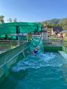 a person riding a water slide in the water at Cabana Iza in Bîrsana