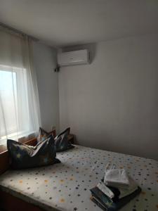 a small bedroom with a bed with a window at Vila Angelys in Tuzla