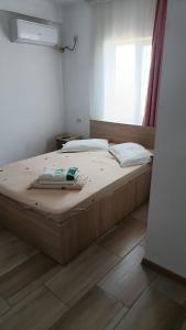 a large bed in a room with a window at Vila Angelys in Tuzla