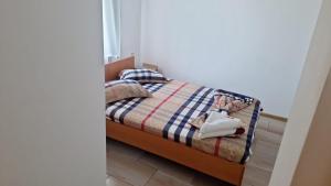 a small bedroom with a bed with a blue and white blanket at Vila Angelys in Tuzla