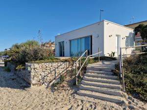 a house on the beach with stairs leading to it at "Le chic" sulla duna fronte mare in Follonica