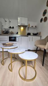 a kitchen with two tables and two chairs at La Perle Rare in Massy