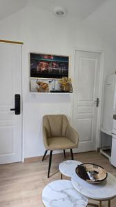 a living room with a chair and two tables at La Perle Rare in Massy