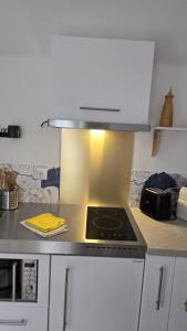 a kitchen with a stove top oven sitting on a counter at La Perle Rare in Massy +35 photos