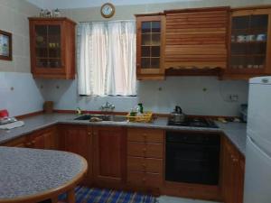 a kitchen with wooden cabinets and a counter top at An excellent getaway choice, in the midst of Qbajjar and Marsalforn Bay! in Żebbuġ