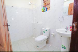 a white bathroom with a toilet and a sink at lexy homes in Ruiru +5 photos