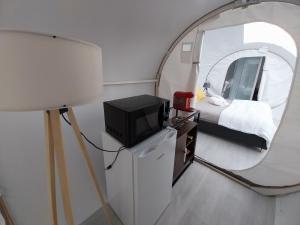 a room with a tv and a mirror at La Bubble in La Salvetat-Peyralès