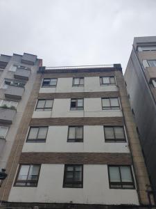 Un edificio alto con ventanas a los lados. en Apartamento Quintela, en Vigo