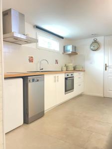 a kitchen with white cabinets and a sink at dday cottage gold beach in Saint-Côme-de-Fresné