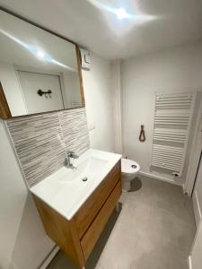 a bathroom with a sink and a mirror and a toilet at dday cottage gold beach in Saint-Côme-de-Fresné +3 photos