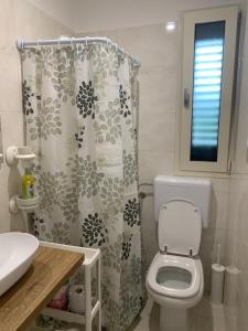 a bathroom with a toilet and a shower curtain at Dimora Anna Maria in Salve