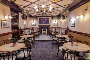 a restaurant with tables and chairs and a fireplace at Globe Inn in Tamworth