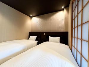 Postel nebo postele na pokoji v ubytování Rinn Hostel Miyagawacho