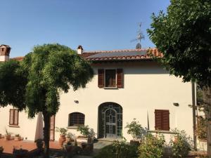 a white house with a tree in front of it at Villa Salviati in Prato