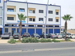 a parking lot with cars parked in front of a building at apparts Large in Oualidia