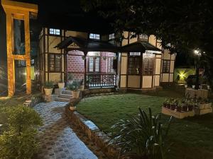 a house with a gazebo in the yard at night at Heritage House Shillong in Shillong