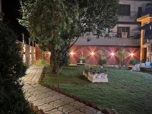 a garden at night with lights on a building at Heritage House Shillong in Shillong
