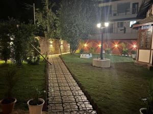 a garden at night with a street light and a building at Heritage House Shillong in Shillong