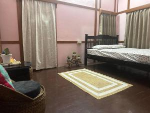 a bedroom with two twin beds and a chair at Heritage House Shillong in Shillong +5 photos