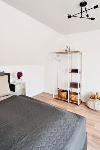 a bedroom with a bed and a white wall at Die Stader Maisonette in Stade
