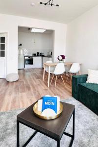 a living room with a couch and a table with a book at Die Stader Maisonette in Stade +21 photos