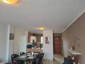 a dining room and kitchen with a table and chairs at Naomi's Place at Stone Arch in Germiston +10 photos