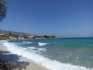 a beach with some waves in the water at Agria Rigani Studios in Samos +20 photos