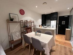 a dining room with a table and chairs and a kitchen at City Apartment with SKY Tower view in Auckland