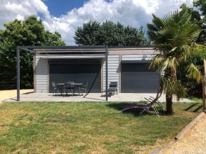 a garage with a table and chairs in a yard at Gîte Ô près Ô in La Souche +4 photos
