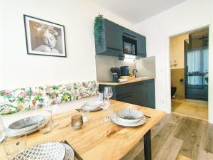 Un comedor con una mesa de madera y una cocina. en Design Apartment für bis zu 4 im 2 OG, modern, Dachterrasse, Grill, ruhige Lage, Disney plus, Wii, LAN und WLAN, en Núremberg 14 fotos más