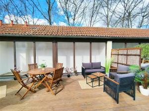 Un patio con una mesa y sillas de madera. en Design Apartment für bis zu 4 im 2 OG, modern, Dachterrasse, Grill, ruhige Lage, Disney plus, Wii, LAN und WLAN, en Núremberg